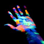 A multi-colored hand on a black background.