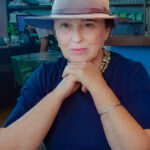 Woman in a blue shirt and a hat with pink detail