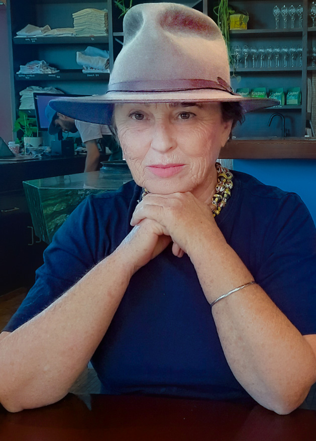 Woman in a blue shirt and a hat with pink detail