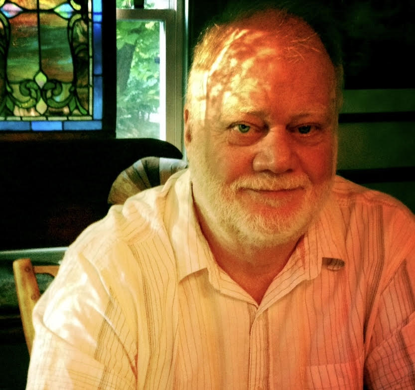 White man with white hair and white shirt, head in sunlight.