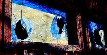 Cracked blue and yellow glass in a wooden frame.
