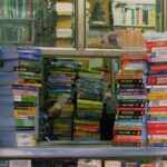 Stacks of books in front of a window.