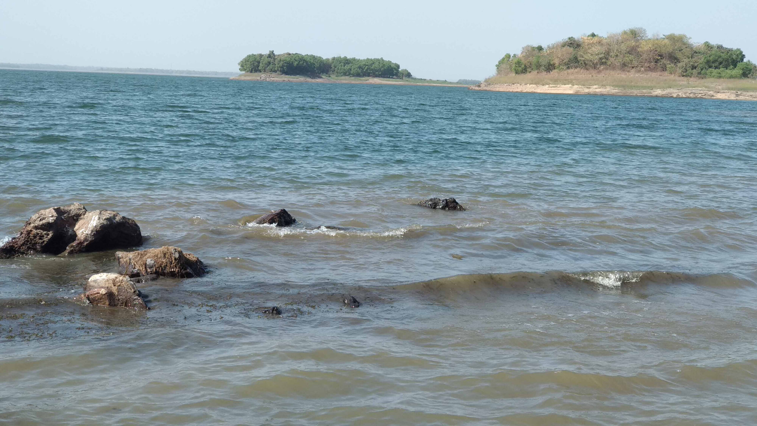 Photo of water, rocks, island in the background